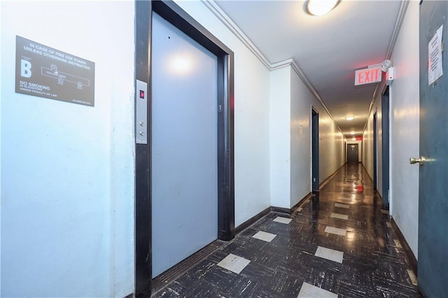 hall featuring baseboards, dark floors, ornamental molding, and elevator