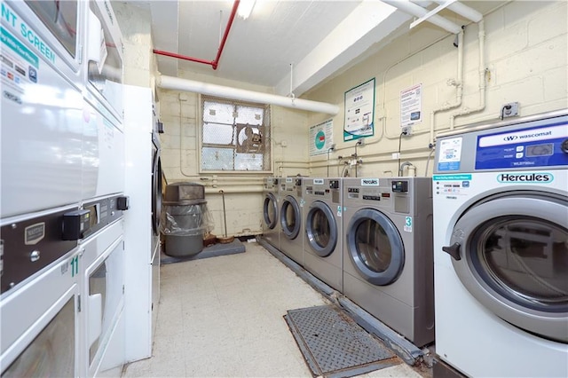 community laundry room featuring concrete block wall, light floors, stacked washer / dryer, and independent washer and dryer