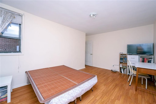 bedroom with baseboards and wood finished floors