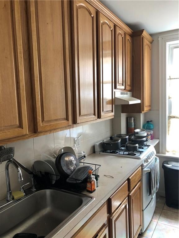 kitchen with a wealth of natural light, sink, extractor fan, and white range with gas stovetop