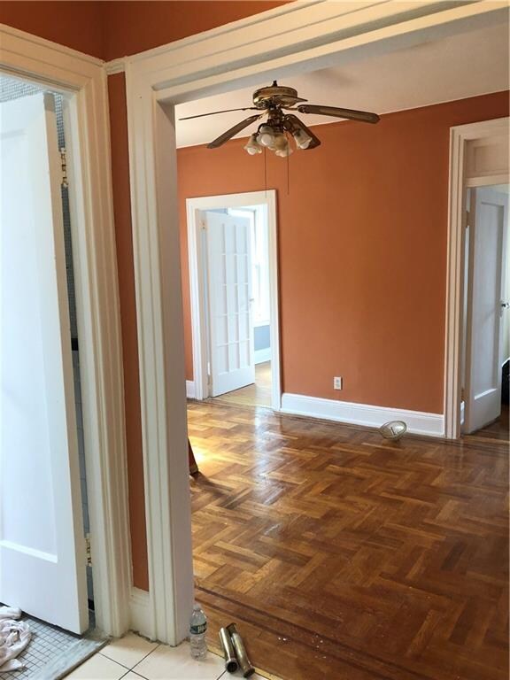 unfurnished room featuring ceiling fan and parquet floors