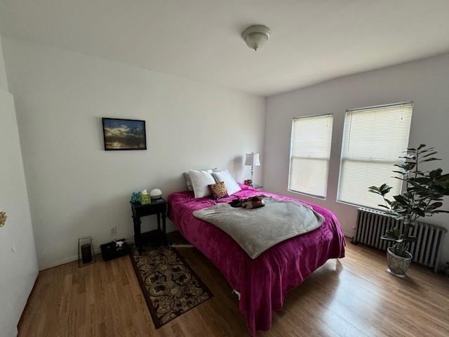 bedroom featuring hardwood / wood-style floors and radiator heating unit