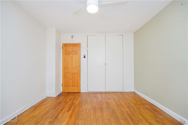 unfurnished bedroom featuring ceiling fan, light hardwood / wood-style flooring, and a closet