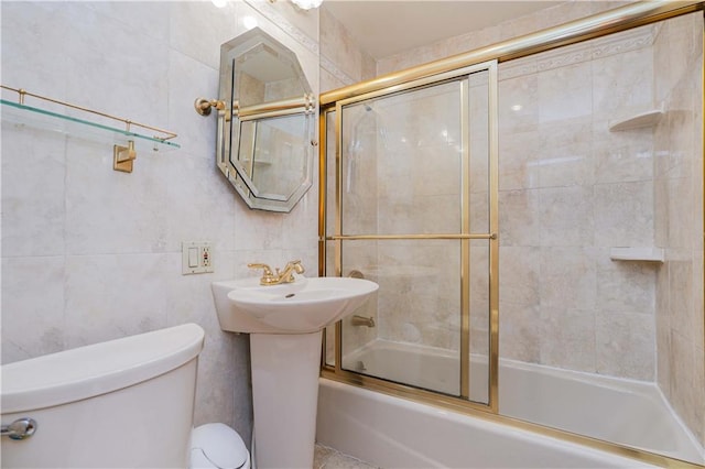 full bathroom featuring sink, toilet, enclosed tub / shower combo, and tile walls