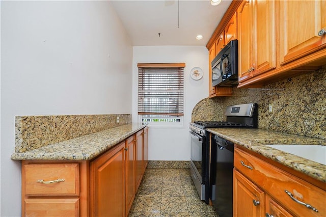 kitchen with light stone countertops, black appliances, and tasteful backsplash