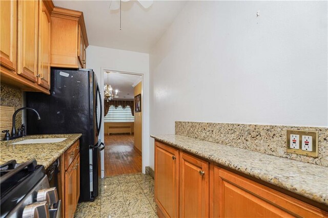 kitchen with tasteful backsplash, stainless steel gas range, sink, ceiling fan, and light stone counters