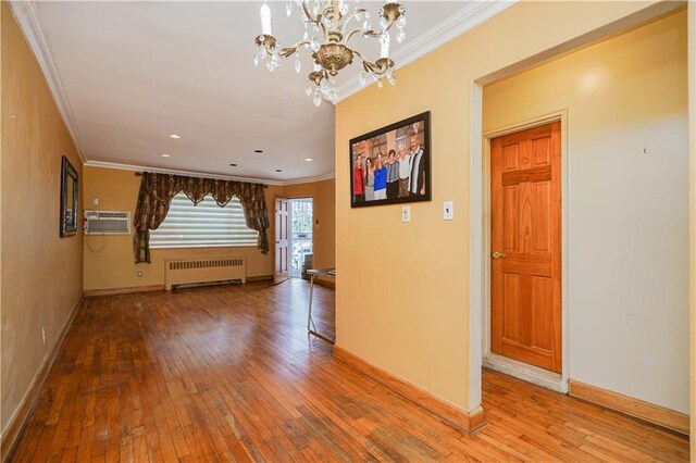 corridor with wood-type flooring, radiator, and ornamental molding