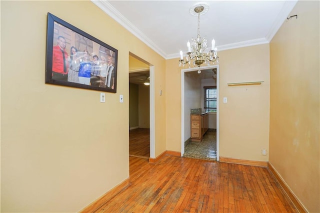 interior space with ceiling fan with notable chandelier, wood-type flooring, and ornamental molding