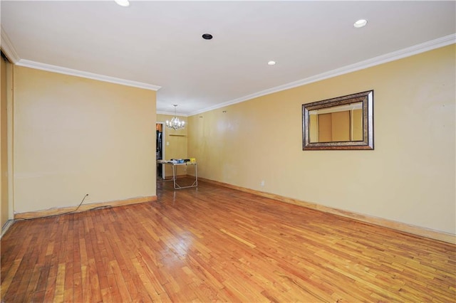 unfurnished room with hardwood / wood-style flooring, crown molding, and a chandelier