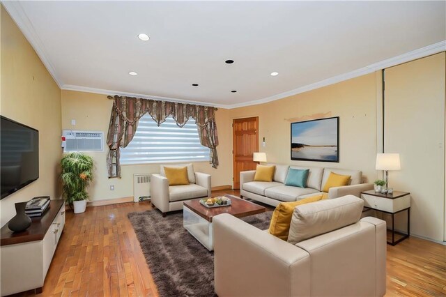 living room featuring crown molding, light hardwood / wood-style flooring, radiator, and an AC wall unit