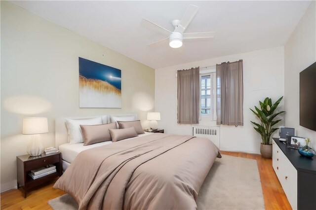 bedroom with ceiling fan, light hardwood / wood-style flooring, and radiator