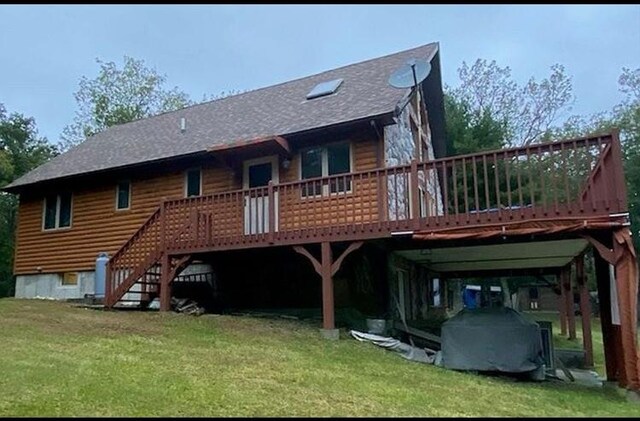 back of property with a wooden deck and a lawn