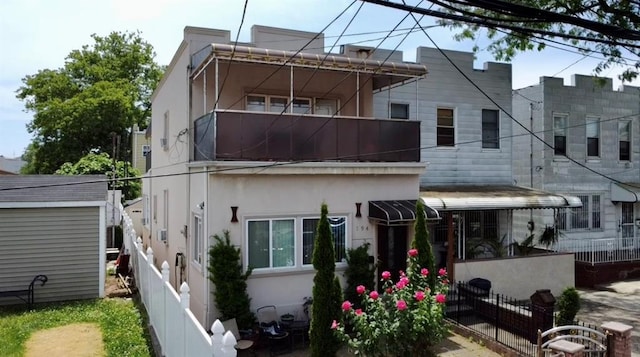 rear view of property with fence and stucco siding