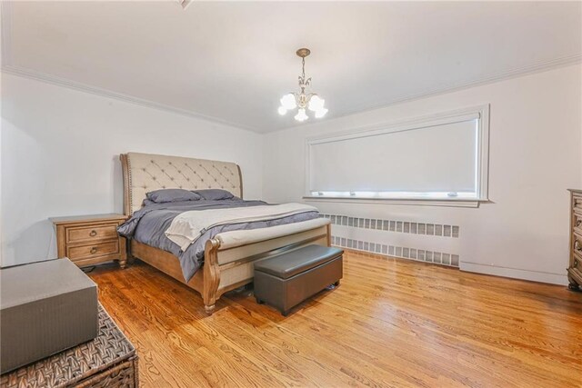 bedroom with ornamental molding, dark wood-type flooring, radiator heating unit, and a notable chandelier