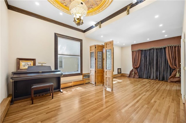 miscellaneous room featuring crown molding, a baseboard heating unit, a chandelier, and light wood-type flooring