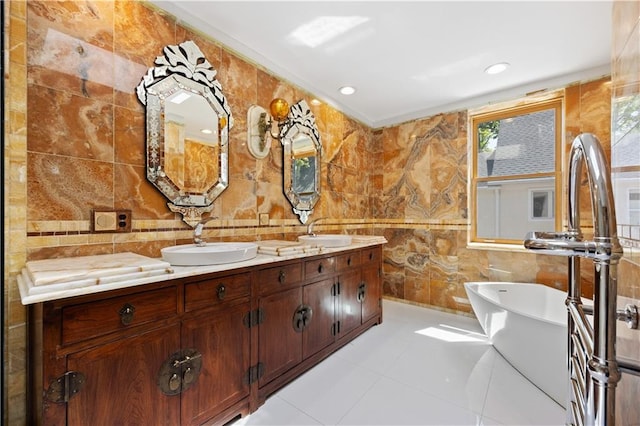 bathroom featuring vanity, tile walls, a washtub, and tile patterned floors