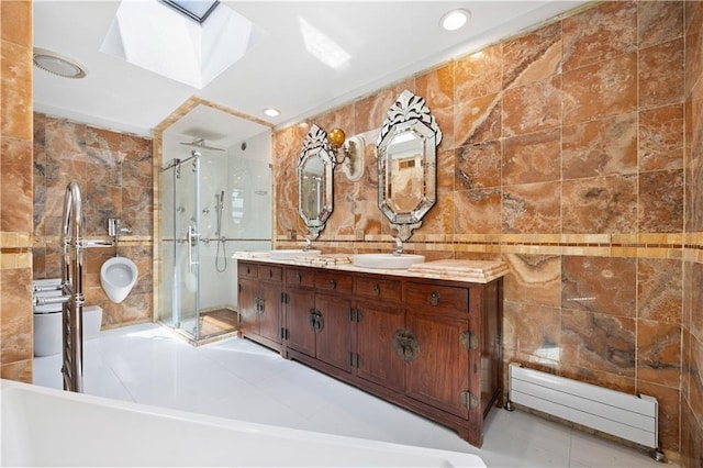 bathroom featuring a skylight, tile walls, vanity, plus walk in shower, and a baseboard heating unit