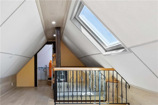 bonus room with lofted ceiling with skylight and hardwood / wood-style floors