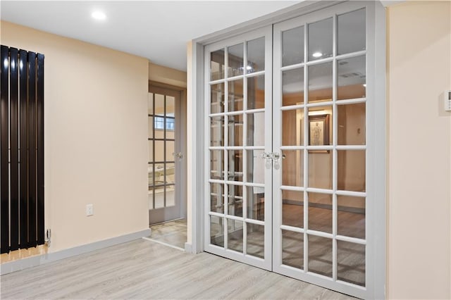 doorway with french doors and light wood-type flooring