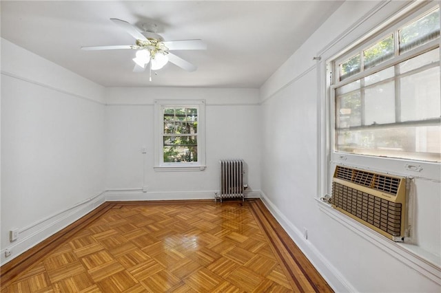 empty room with radiator, light parquet flooring, and ceiling fan