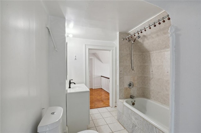 bathroom featuring tile patterned flooring, tiled shower / bath, toilet, and vanity