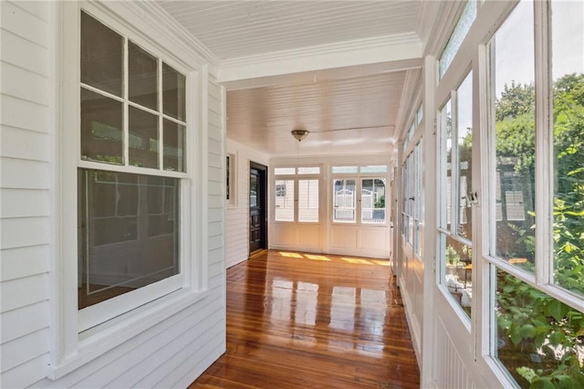 unfurnished sunroom featuring crown molding and hardwood / wood-style floors