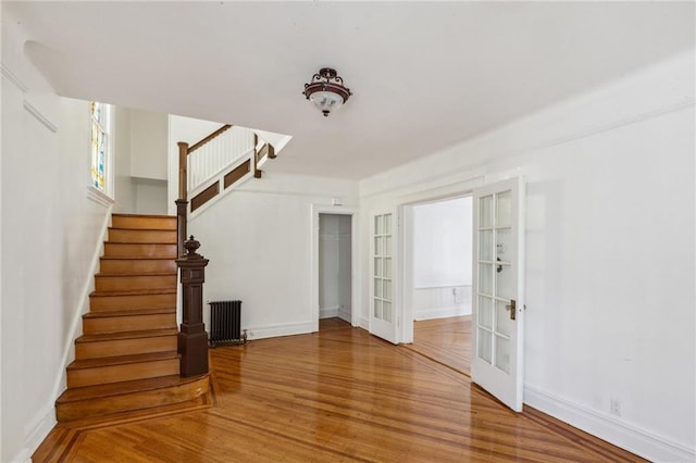 interior space featuring baseboards, radiator, and wood finished floors