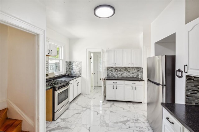 kitchen with a sink, marble finish floor, appliances with stainless steel finishes, and tasteful backsplash