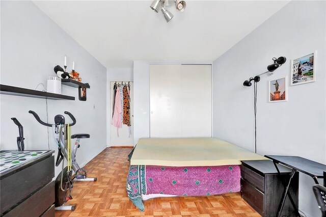 bedroom featuring a closet and light parquet floors