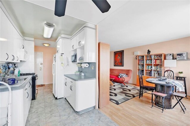 kitchen with backsplash, white cabinets, white appliances, and light hardwood / wood-style floors