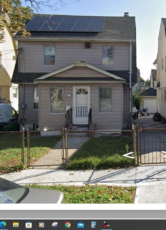 191-40 112th Rd, Saint Albans, NY 11412 - view of front facade featuring a gate, roof mounted solar panels, and a fenced front yard
