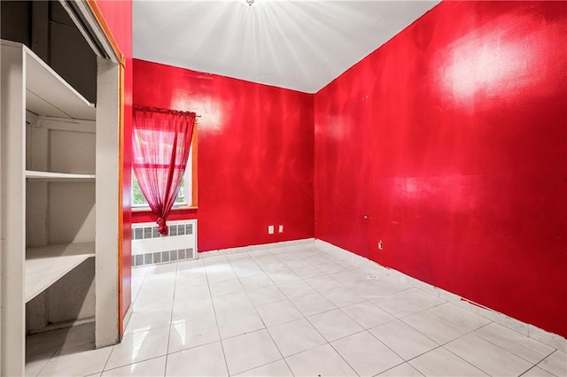 spare room with radiator and tile patterned floors