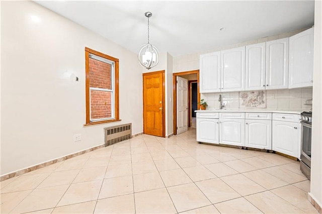 kitchen featuring light countertops, radiator heating unit, white cabinets, and decorative backsplash