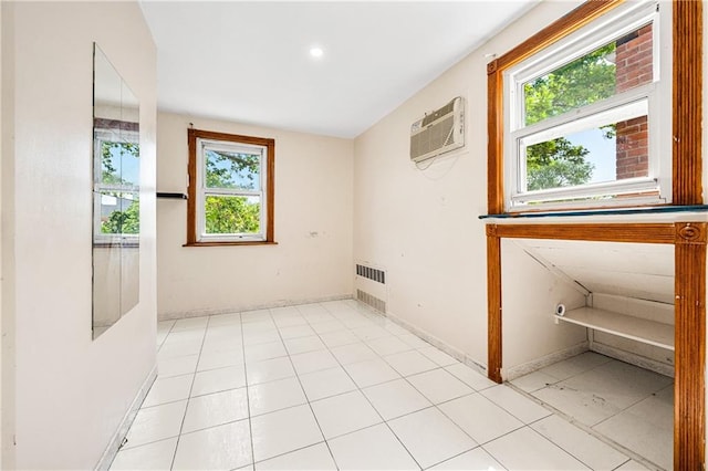 empty room featuring an AC wall unit, radiator, and baseboards