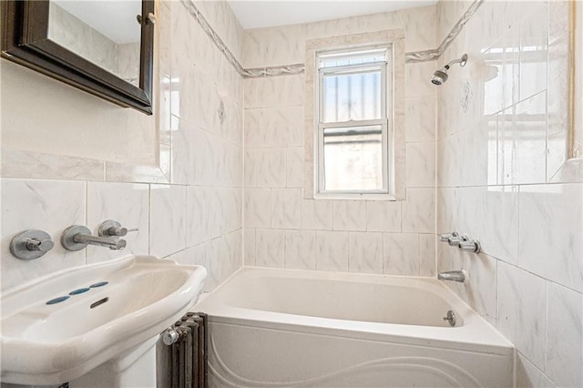 bathroom with a sink, tile walls, and shower / bathing tub combination