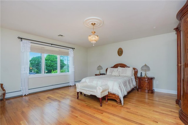 bedroom featuring light hardwood / wood-style flooring and a chandelier