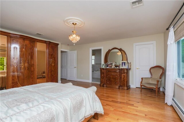 bedroom featuring connected bathroom, light hardwood / wood-style flooring, and baseboard heating