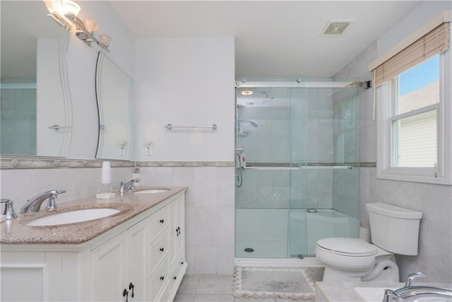 bathroom featuring tile walls, tile patterned flooring, toilet, and walk in shower