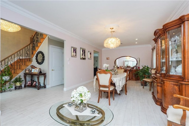 dining space featuring ornamental molding, a chandelier, and light hardwood / wood-style floors