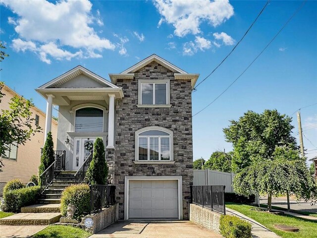40 Di Marco Pl, Staten Island, NY 10306 - view of front of house with a garage, fence, concrete driveway, and stone siding