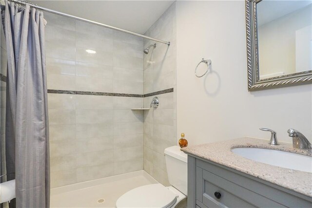 bathroom with vanity, curtained shower, and toilet