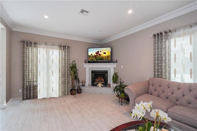 living room with a premium fireplace, light wood-type flooring, and ornamental molding