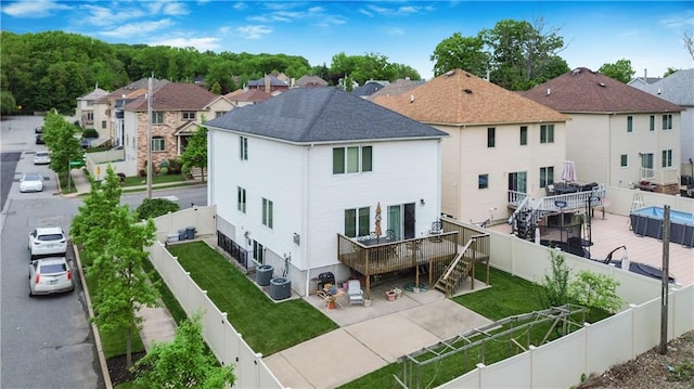 back of property featuring cooling unit, a wooden deck, and a yard