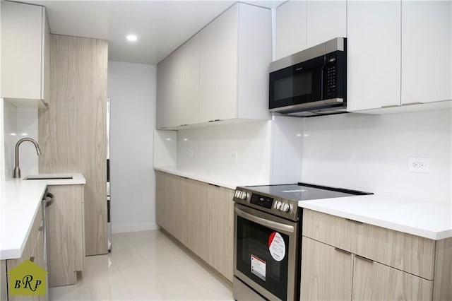 kitchen with white cabinetry, sink, and appliances with stainless steel finishes