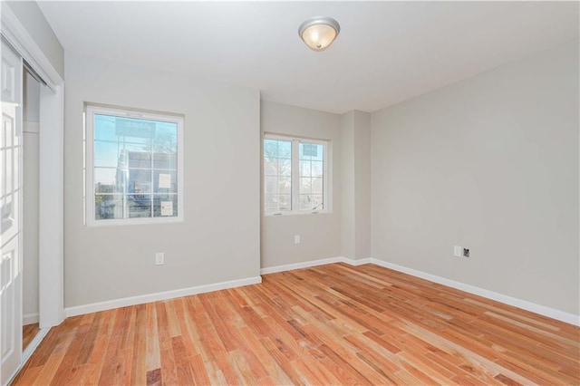 empty room with light wood-type flooring and baseboards