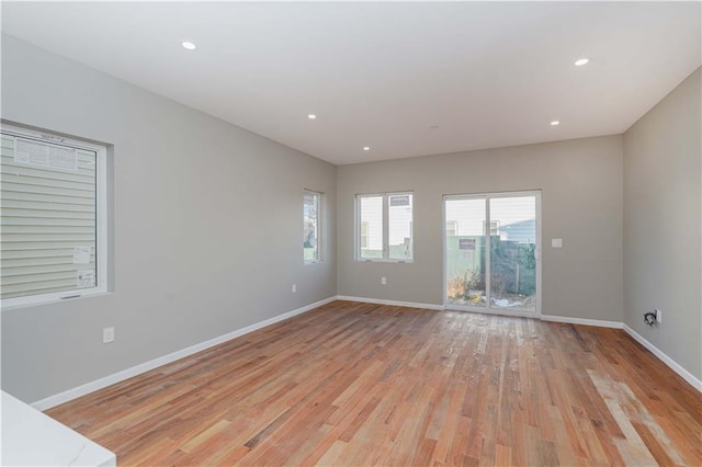 unfurnished room with light wood finished floors, recessed lighting, and baseboards