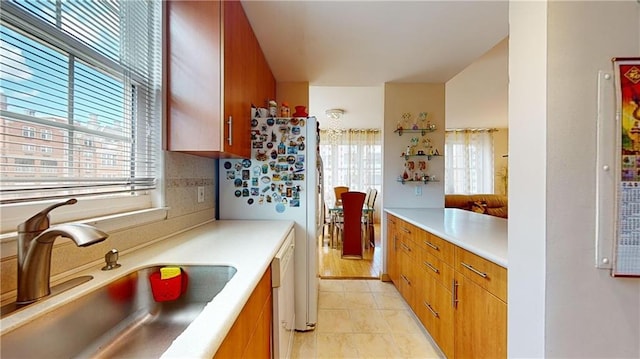 kitchen featuring sink, backsplash, white fridge, and light tile patterned flooring