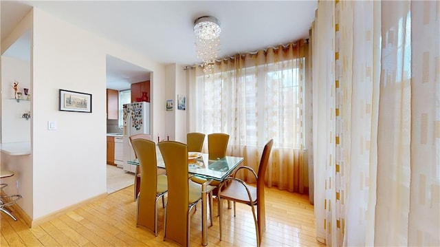 dining room featuring light hardwood / wood-style floors and a notable chandelier