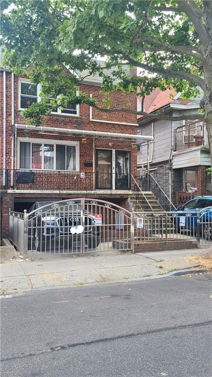 view of property featuring a fenced front yard, stairway, and brick siding