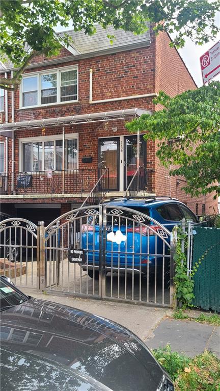 exterior space featuring a gate, a fenced front yard, and brick siding